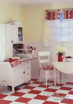 a kitchen with red and white checkered flooring next to a dining room table