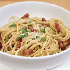 a white bowl filled with pasta and bacon