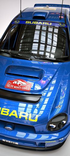 the front end of a blue race car with its lights on and bumper stickers down