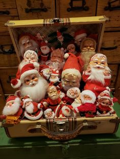 an old suitcase filled with santa claus figurines