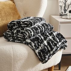 two black and white blankets sitting on top of a chair