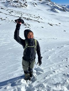 a man standing on top of a snow covered slope