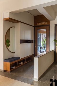 an entry way with a bench, mirror and potted plant on the side wall