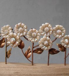 some white flowers and leaves on top of a wooden table