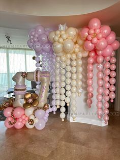 some balloons are hanging from the ceiling in front of a table and chair with other decorations