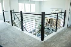 a living room filled with furniture and a metal railing over the top of a carpeted floor