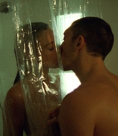 a man and woman standing in front of a shower with clear plastic on the walls