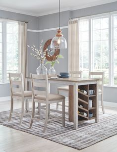 a dining room table and chairs in front of windows