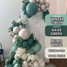 a white and green balloon arch with flowers on it in front of a wall that reads winter green sage green retro white