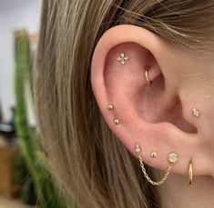 a close up of a person's ear with three different piercings on it