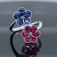 Blue Sapphire & Ruby Precious Petals Ring 1.24ct TW AAA Grade Natural Ruby1.30ct TW AAA Grade Natural Sapphire 18K White Gold Perle framed blossoms of AAA grade natural rubies and sapphires. Diamond centers set in lovely 18k white gold. .10ctw diamond 1.24ctw rubies 1.30ctw sapphires Ruby And Sapphire Wedding, Ruby Jewelry Ring, Ruby And Diamond Ring, Blue Sapphire Ring, Diamond Necklace Set, Earrings Design, Sapphire Wedding, Popular Fashion, Ruby Jewelry