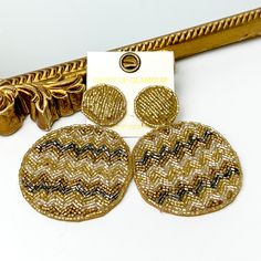 These are circle post back, gold beaded earrings with a beaded circle drop. These earrings include a chevron pattern with gold beads, silver beads, and light gold beads. These earrings are pictured in front of a gold mirror on a white background. Trendy Round Beaded Earrings, Trendy Round Beaded Earrings For Parties, Spring Beaded Round Earrings, Summer Party Round Beaded Earrings, Spring Party Earrings With Round Beads, Trendy Circular Beaded Earrings, Gold Round Beaded Earrings For Summer, Trendy Gold Beaded Earrings, Bohemian Gold Beaded Earrings For Spring