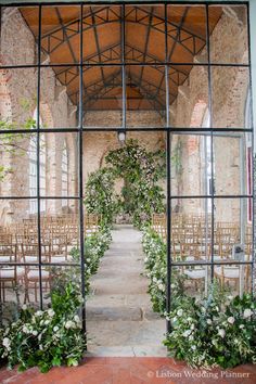 an outdoor wedding ceremony with flowers and greenery on the arch, surrounded by chairs