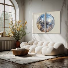 a living room filled with furniture and a mirror ball wall hanging on the wall next to a window