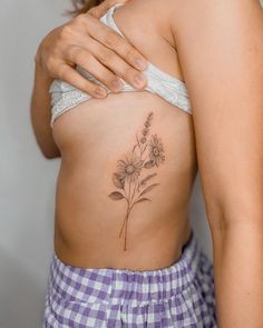 a woman with a flower tattoo on her stomach