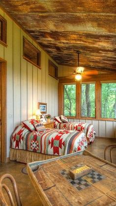 two beds in a room with wooden walls and ceiling beams, next to a coffee table