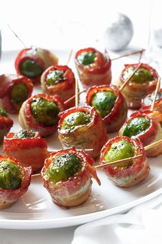 small appetizers are arranged on a plate with toothpicks