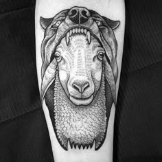 a black and white sheep tattoo on the arm