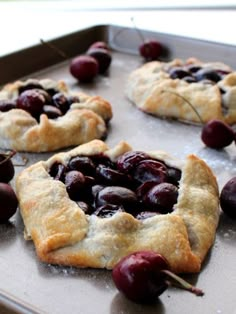 cherry pastries on a baking sheet ready to go into the oven with cherries