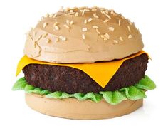 a hamburger made out of chocolate frosting and sprinkled with sesame seeds on top