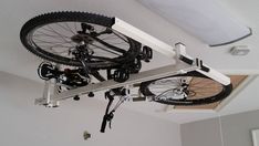 a bicycle is mounted to the ceiling in a room with white walls and carpeting