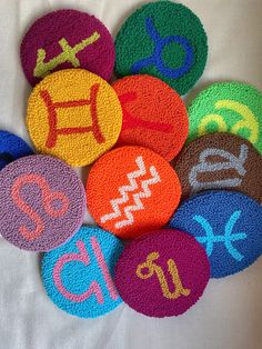 a pile of colorful magnets sitting on top of a white table covered in writing