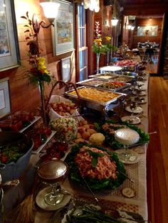 a buffet line with many different types of food on the table, including salads and other foods