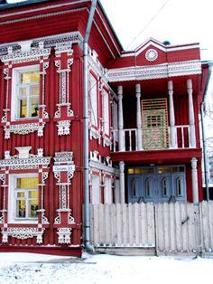 a red building with white trim on the front and side of it's windows