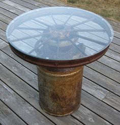 a round glass table sitting on top of a wooden deck