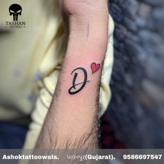 a person with a small tattoo on their arm that has the letter q in it