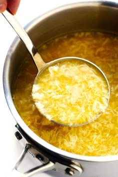 a ladle full of grated cheese in a pot