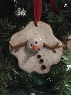 a snowman ornament hanging from a christmas tree