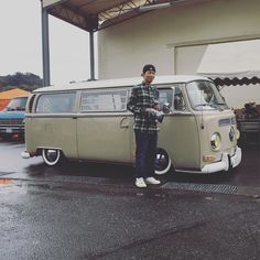 a man standing in front of an old vw bus