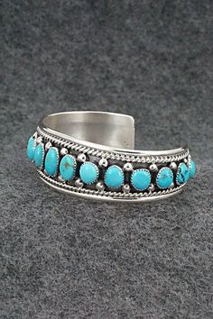 This turquoise and sterling silver bracelet was made by Zuni silversmith Chester Charley. The inside is signed CC and sterling.Size: 5 1/4" (will fit up to a 6 3/8" wrist)Gap: 1 1/8"Width: 7/8"Free shipping on all orders! We ship with USPS and always include tracking. All orders ship within a day of payment.Returns are accepted up to 30 days after you receive your order. Just send us a message. Our shop offers cash back or store credit. The item must be returned in new condition. Formal Oval Turquoise Bracelet, Classic Handmade Turquoise Bracelets, Classic Turquoise Adjustable Bracelet, Artisan Turquoise Jewelry For Formal Occasions, Blue Oval Sterling Silver Cuff Bracelet, Oval Turquoise Collectible Bracelet, Turquoise Bracelet Jewelry Collectible, Turquoise Bangle For Formal Occasions, Formal Turquoise Bangle Jewelry