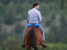 a man riding on the back of a brown horse