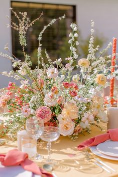 a table set with flowers and candles for an elegant dinner party or wedding reception at home