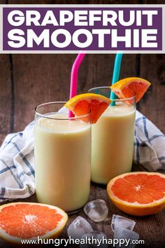 grapefruit smoothie in two glasses with orange slices and strawberries on the side