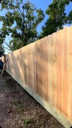 a wooden fence is shown in front of some trees