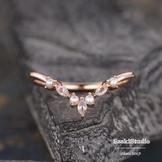 a rose cut diamond and pearl ring on top of a rock