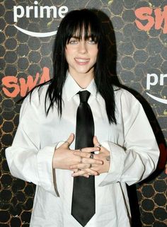 a woman with black hair wearing a white shirt and tie, posing for the camera