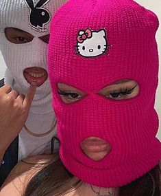 two girls wearing hello kitty knitted ski masks and pointing at the camera with their fingers