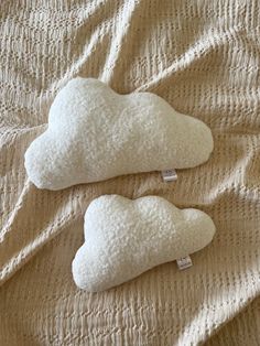 two pillows that are sitting on a bed