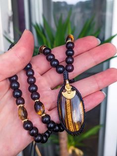 Read to the end before ordering . Magnificent necklace made of 6mm ebony wood beads and tiger's eye, stainless steel spacers. High quality Tiger's Eye macrame pendant and brass tribal charm. . The necklace adjusts with a sliding knot. . IMPORTANT All our shipments are by standard tracked letter or simple colissimo depending on the item selected. . We are not responsible for delays/losses/theft with the "standard shipping" or colissimo option without insurance. . If you want insurance in case of Tiger Eye Necklace Handmade, Men Tiger Eye Necklace, Tiger Eye Pendant, Tiger Necklace, Macrame Pendant, Tigers Eye Necklace, Tiger Eye Beads, Ebony Wood, Sliding Knot