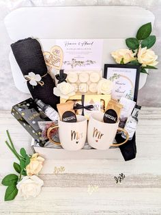 a gift basket with coffee mugs, flowers and other personalized items in it