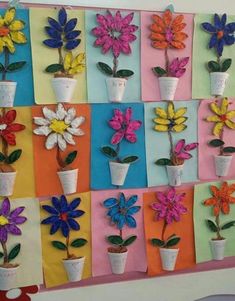 colorful paper flowers are arranged on the wall