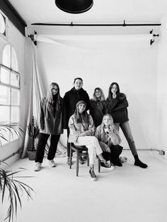 a group of people are posing for a black and white photo in an empty room