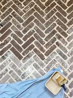 a blue towel is laying on the floor next to a brush