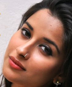 a close up of a woman with a nose piercing