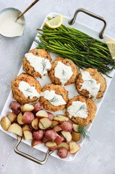 potatoes, asparagus and other vegetables on a plate with ranch dressing next to it