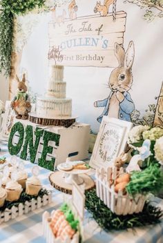 a table topped with cakes and cupcakes on top of a checkered table cloth